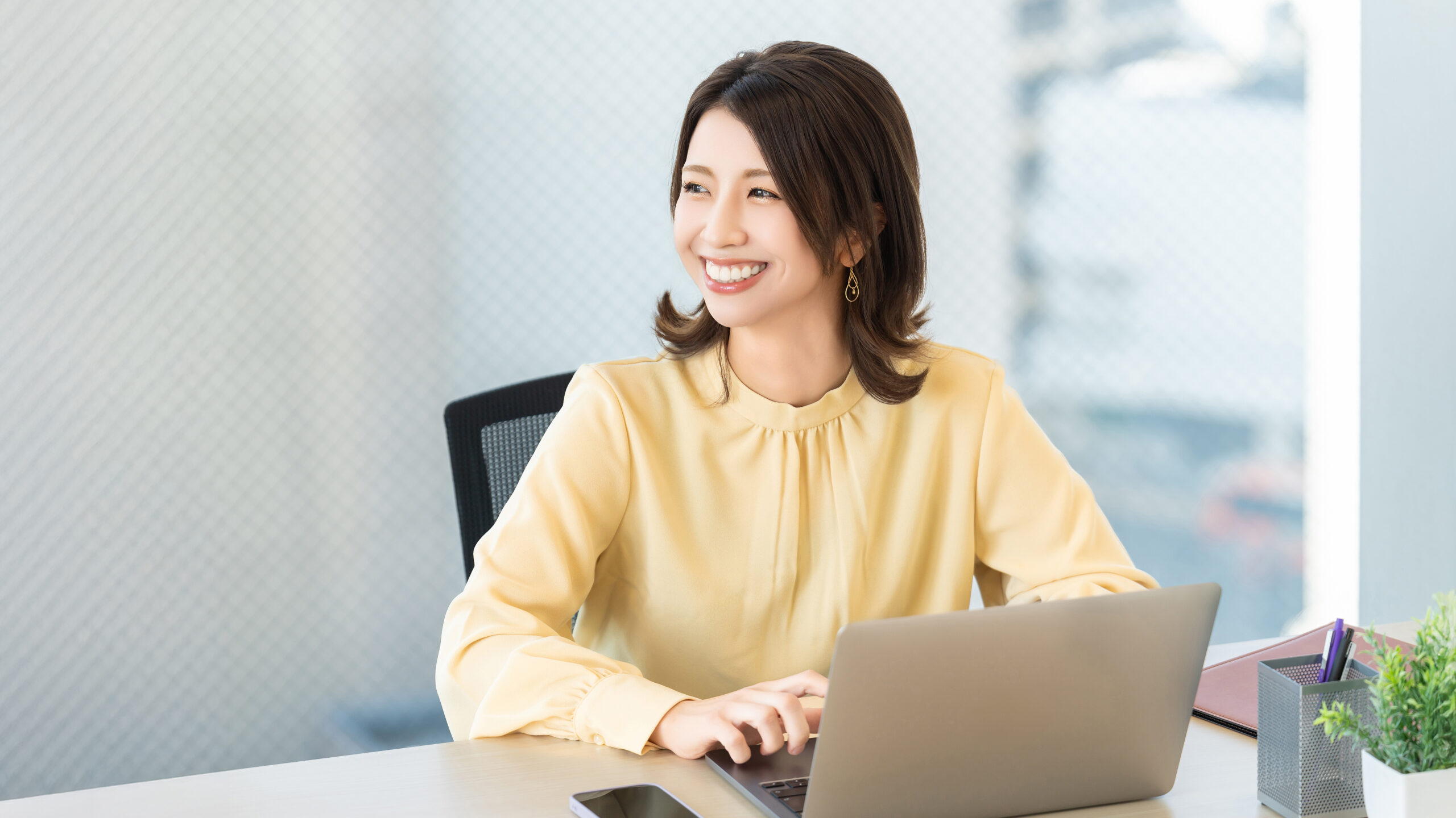 デスクワークをする笑顔の女性・ビジネスウーマン